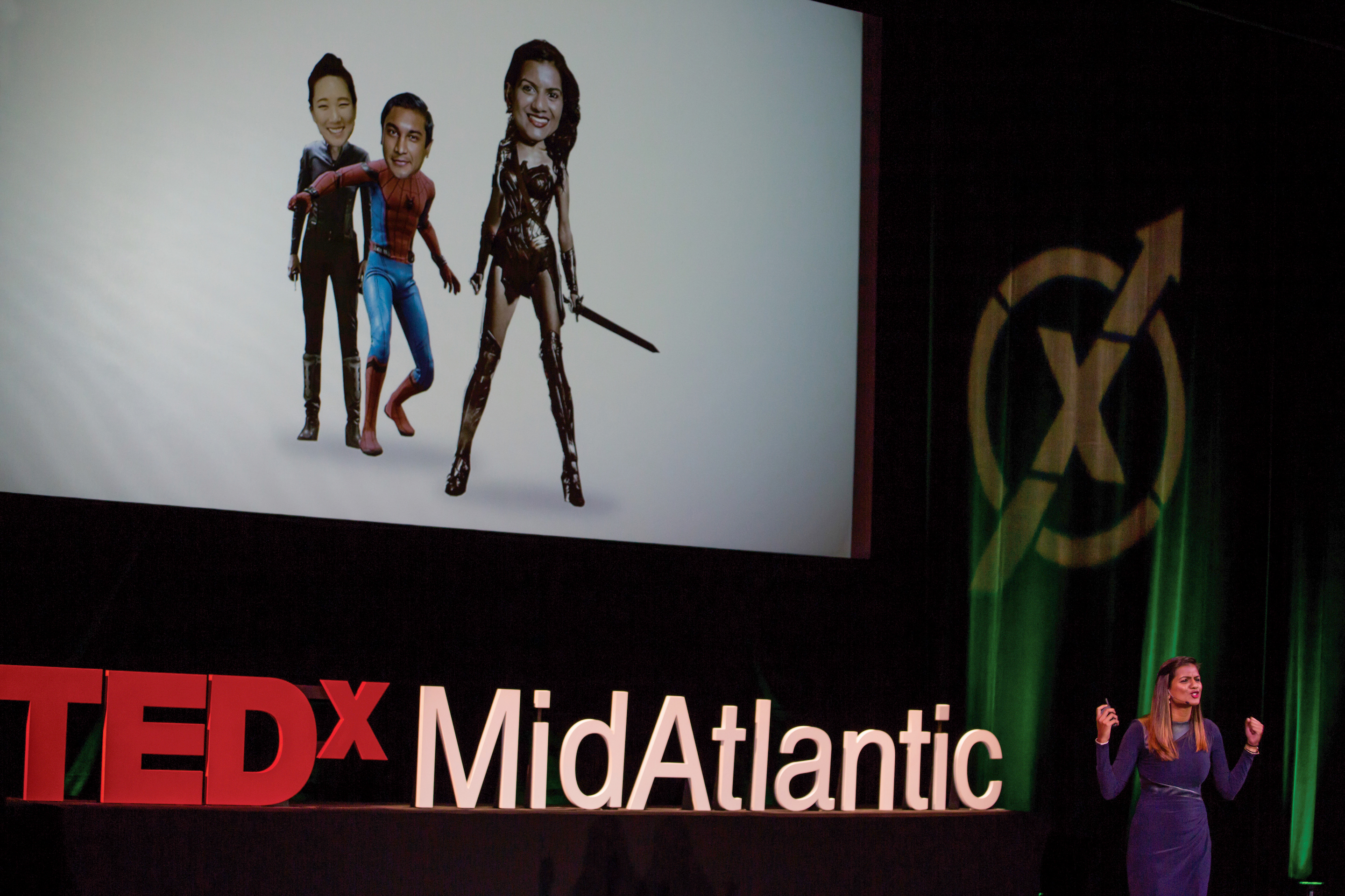 Hasini on stage presenting at Ted-X Midatlantic in front of an image collage by Martin Rietveld